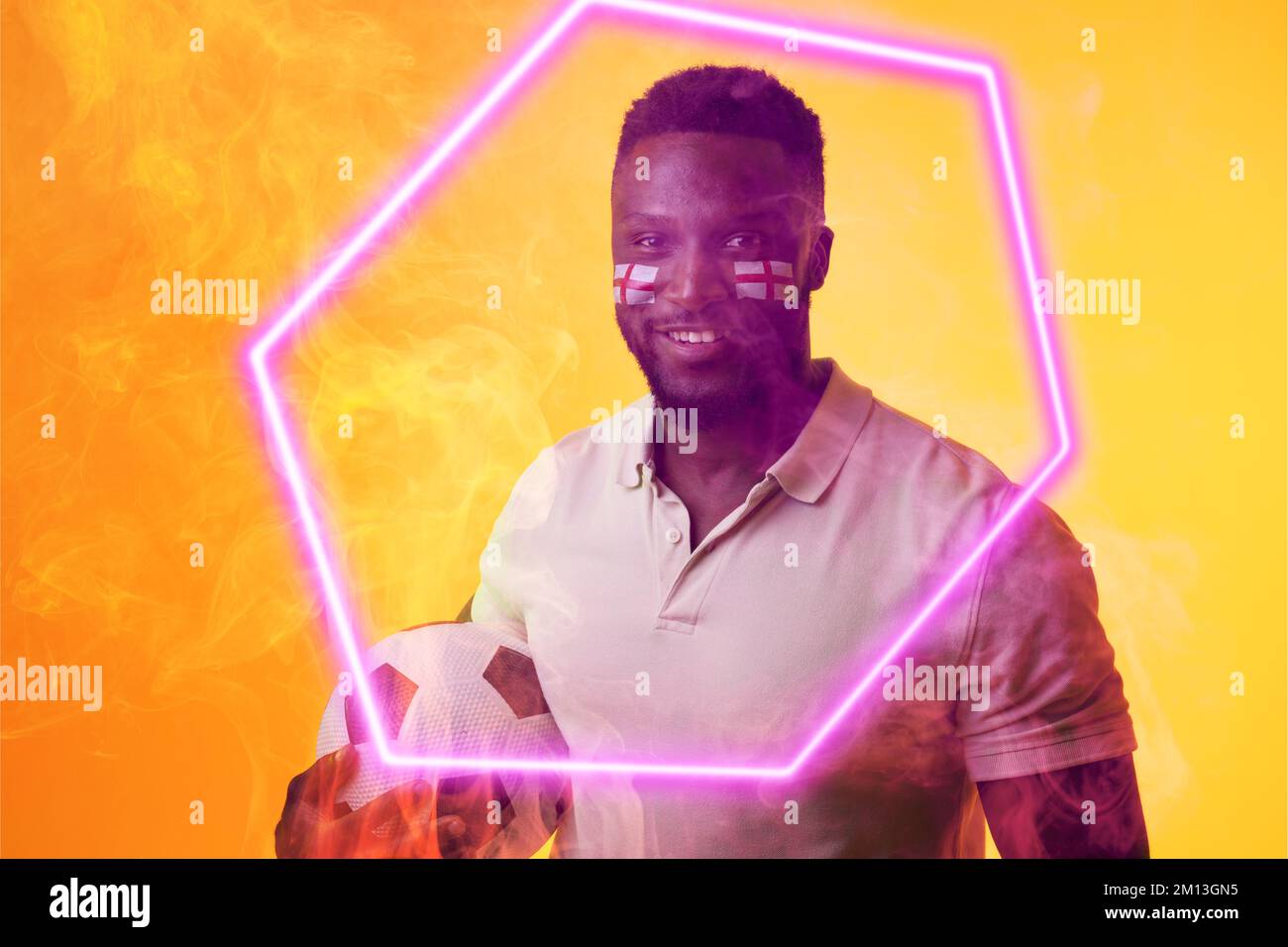 Souriant fan d'afro-américain avec balle et drapeau d'angleterre de la peinture de visage par hexagone illuminé Banque D'Images