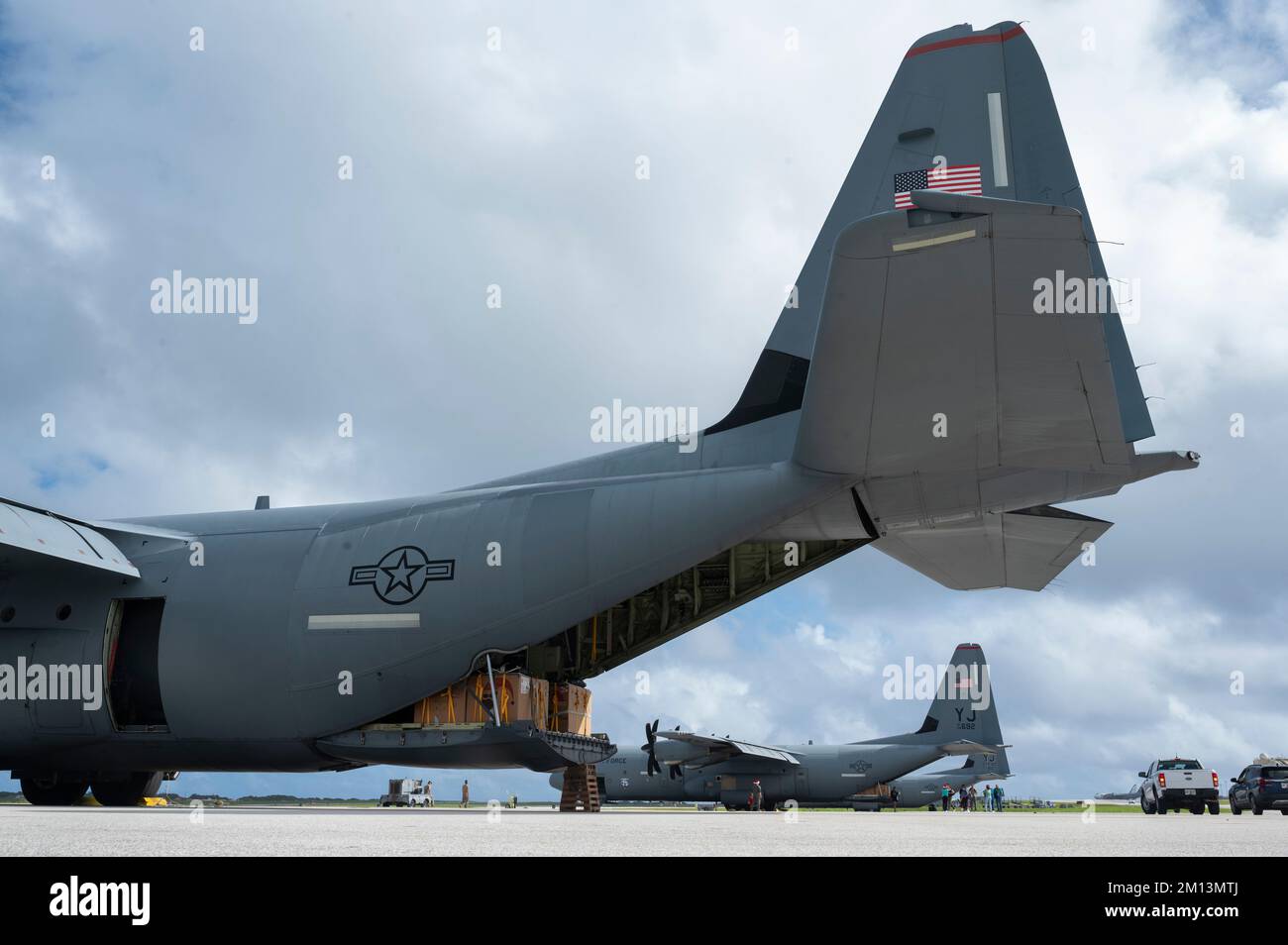 Trois États-Unis Le Super Hercules de la Force aérienne C-130J de l'escadron de transport aérien expéditionnaire (EAS) 36th de la base aérienne de Yokota, au Japon, est chargé de colis d'approvisionnement pour l'opération Christmas Drop 2022 sur la ligne de vol de la base aérienne d'Andersen, à Guam, le 6 décembre 2022. L'opération Christmas Drop est la plus longue mission humanitaire du ministère de la Défense qui fournit une aide critique aux communautés insulaires dans l'ouest du Pacifique tout en offrant aux équipages l'occasion d'affiner les compétences importantes nécessaires pour les opérations futures. (É.-U. Photo de la Force aérienne par le sergent d'état-major Jerreht Harris) Banque D'Images