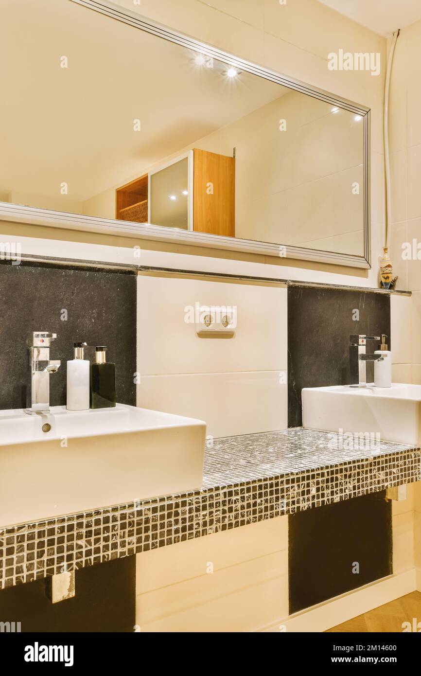 Placard avec évier et miroir fixé au mur de carrelage près de la porte et  un sèche-linge dans les toilettes modernes Photo Stock - Alamy