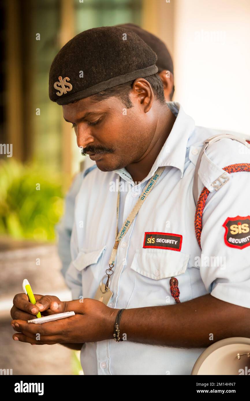 PUDUCHERRY, INDE - MARS CIRCA, 2020. Un agent de police indien qui vérifie l'entrée à l'hôpital, en écrivant les noms de famille dans le livre. Banque D'Images