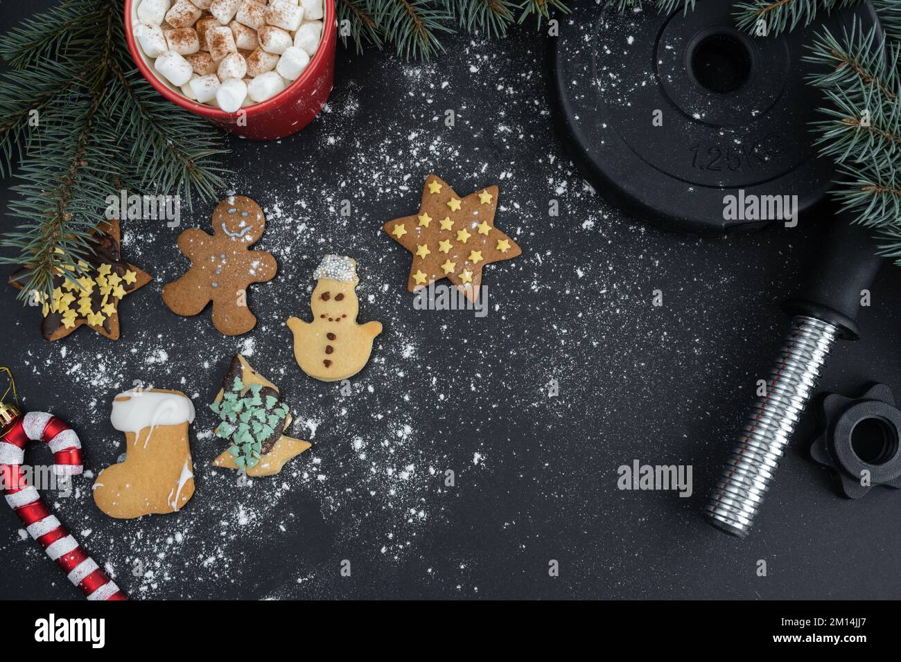 Biscuits de pain d'épice, assiette de poids de barbell de gym, chocolat chaud cacao avec guimauves, branches d'arbre de Noël. Remise en forme hiver régime plat. Banque D'Images