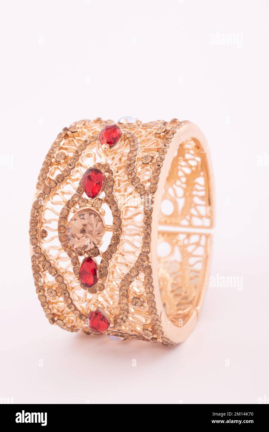 Bracelet or femelle avec pierre rouge isolée sur fond blanc Banque D'Images