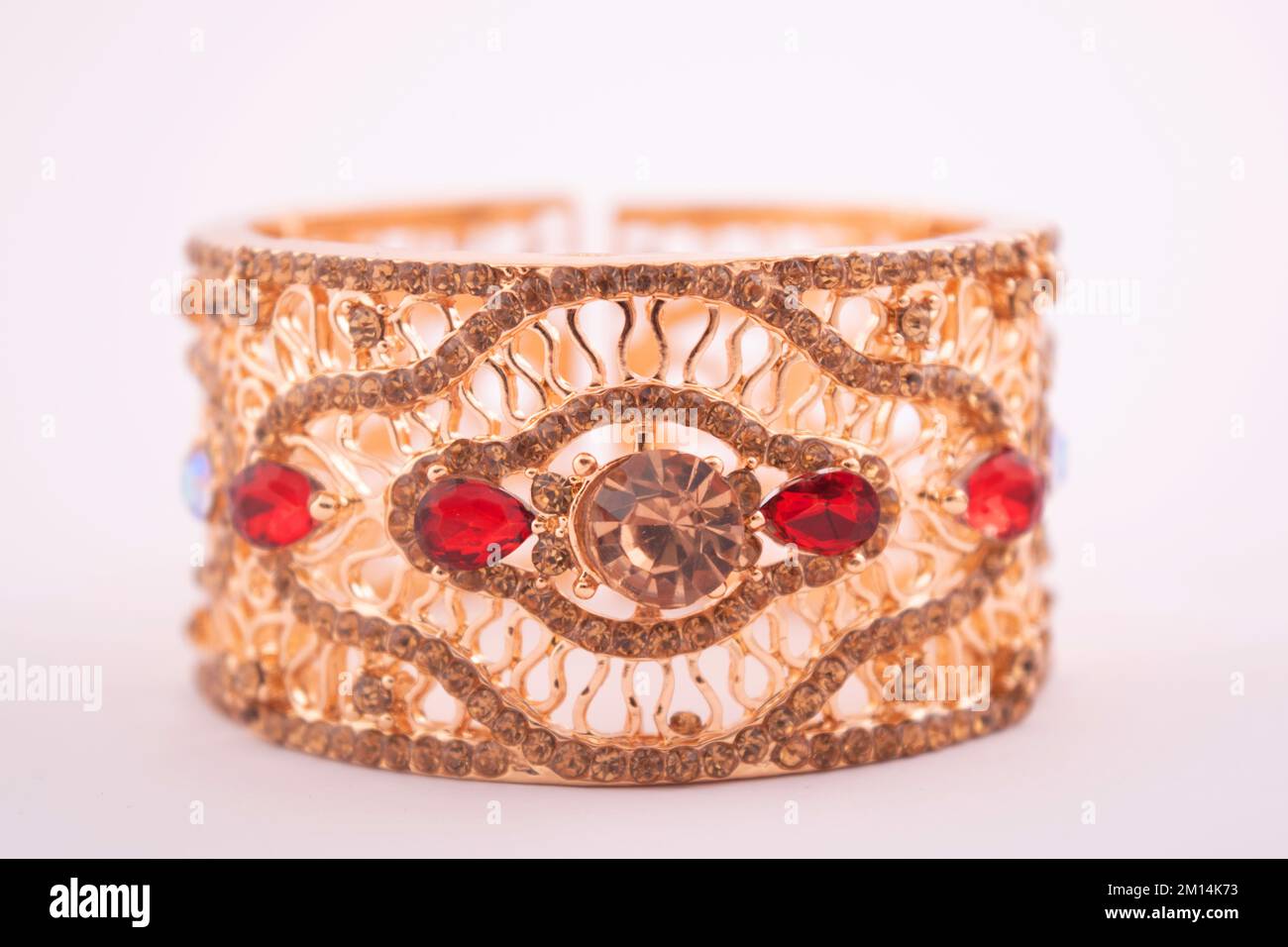 Bracelet en or semi-précieux avec pierre rouge isolée sur fond blanc Banque D'Images