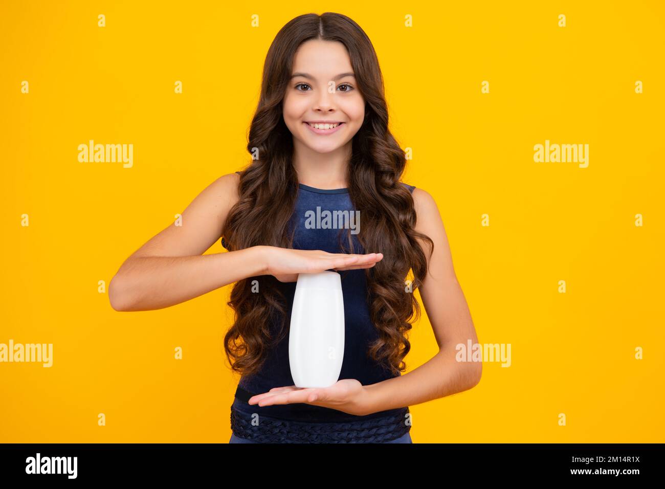 Enfant avec après shampooing. Soins cosmétiques quotidiens. L'adolescent de 12, 13, 14 ans tient une bouteille de soins pour les cheveux et la peau. Beauté santé et cosmétiques Banque D'Images
