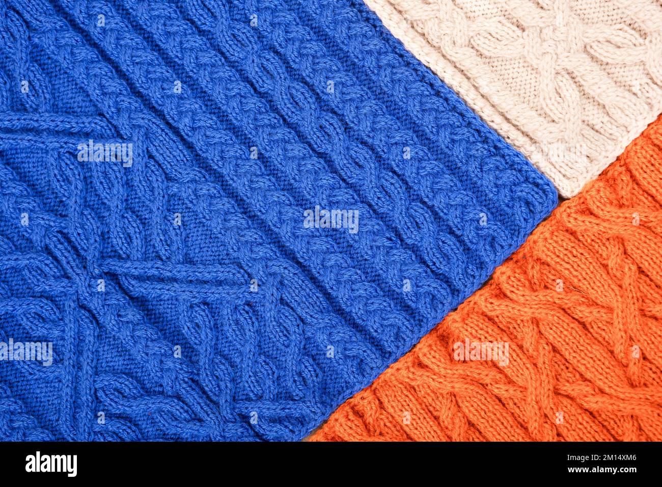 Fond bleu orange et beige. Grand tissu tricoté avec un motif. Gros plan d'une couverture tricotée. Banque D'Images