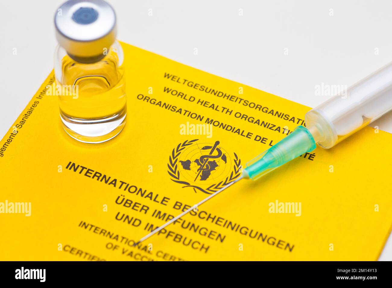 Gros plan du document de vaccination jaune de l'organisation mondiale de la chaleur avec une seringue et un flacon Banque D'Images