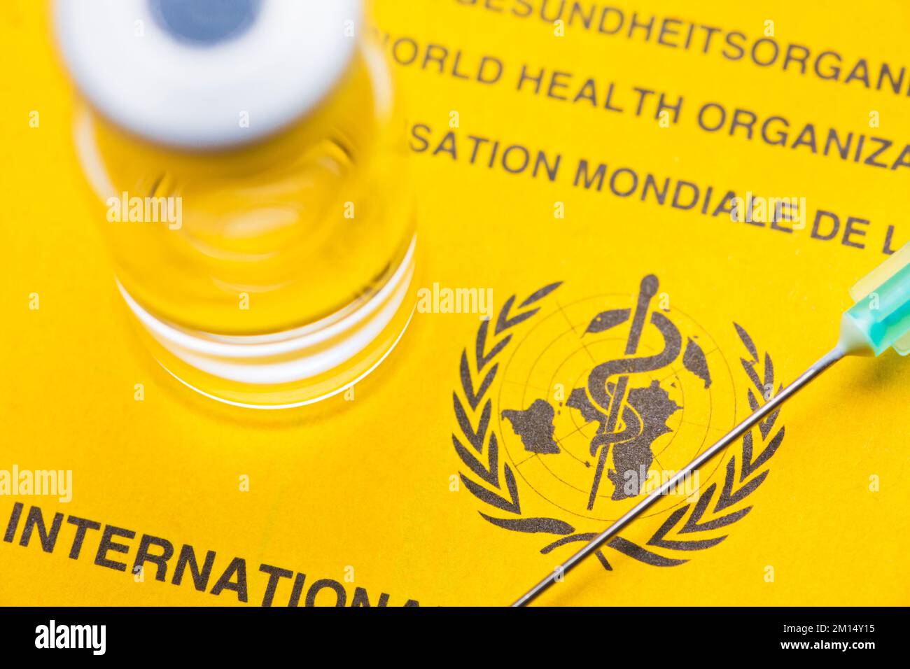 Gros plan du document de vaccination jaune de l'organisation mondiale de la chaleur avec une seringue et un flacon Banque D'Images
