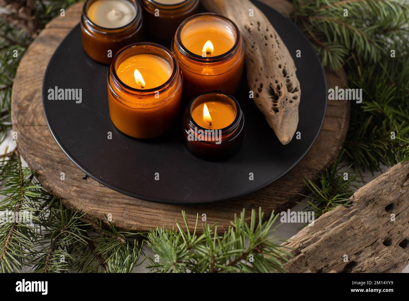 Les bougies de soja brûlent dans des pots en verre. Confort à la maison. Bougie dans un pot brun. Parfum et lumière. Bougie parfumée faite à la main. Aromathérapie. Arbre de Noël et ambiance d'hiver. Décoration chaleureuse. Décoration de fête Banque D'Images