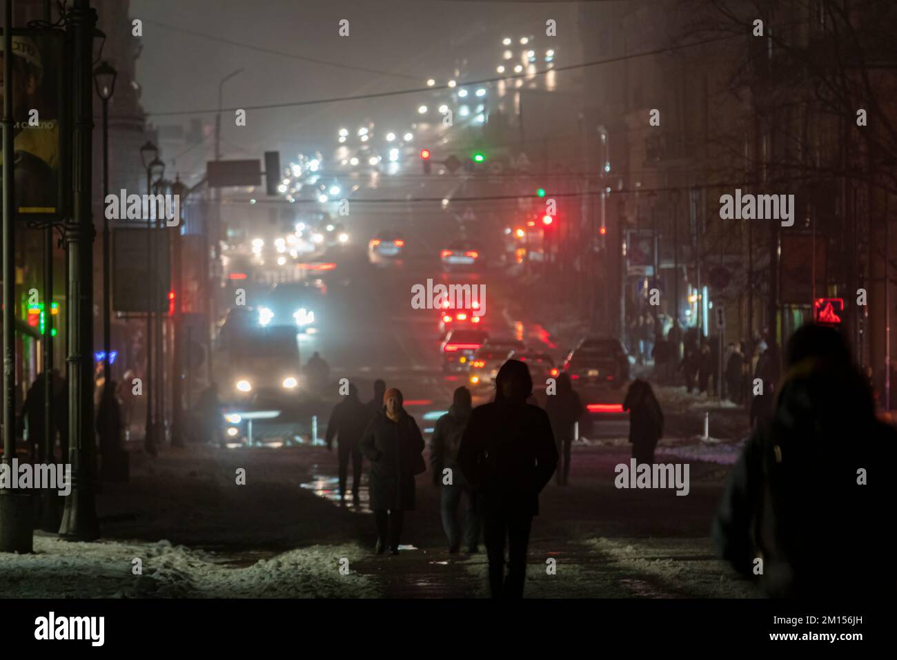 2022-12-08 Kiev, Ukraine. Silhouette de piétons dans la ville de nuit brumeuse. Pannes de courant à Kiev Banque D'Images