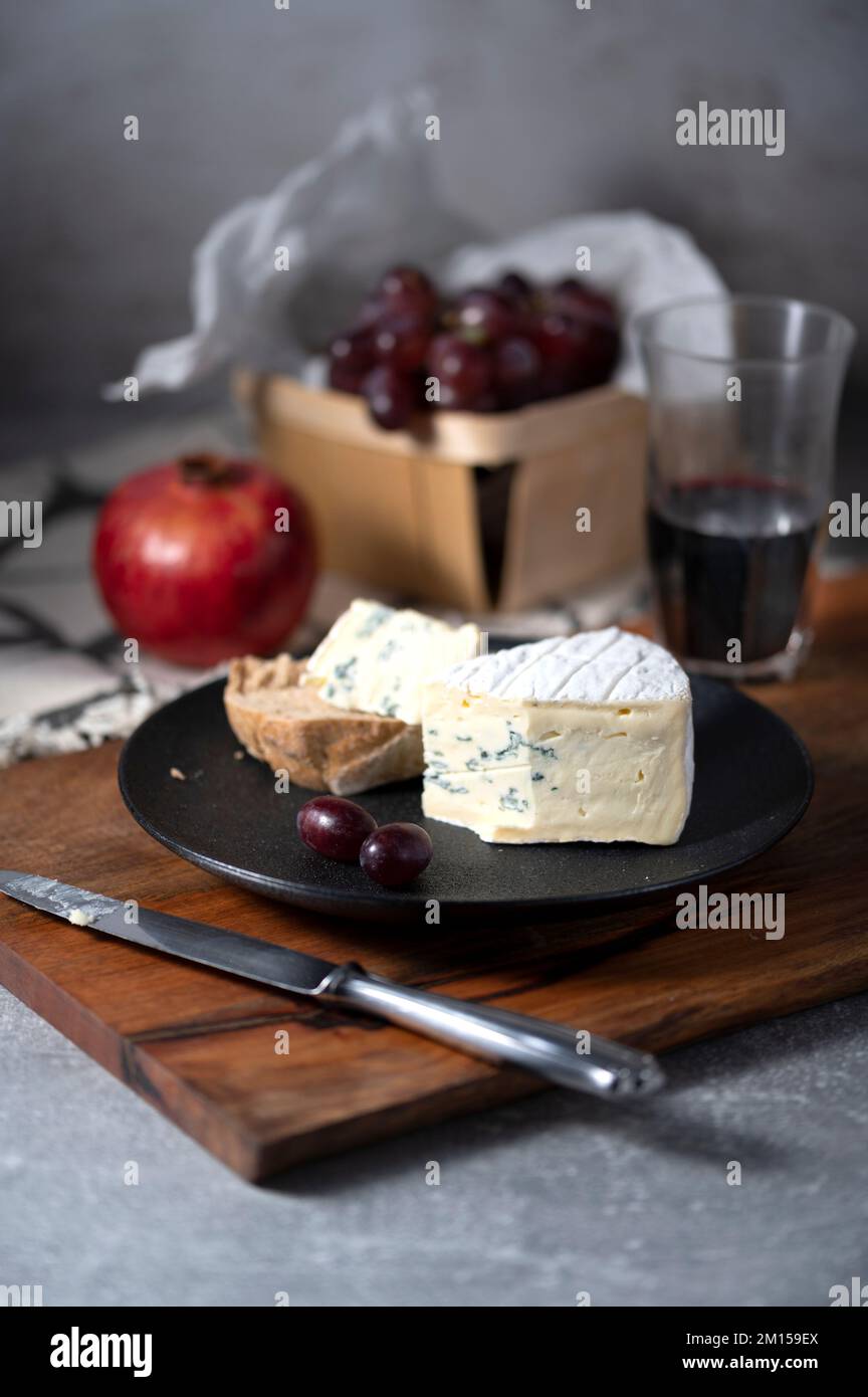 Morceau de fromage bleu avec des raisins de pain et grenade sur la table Banque D'Images