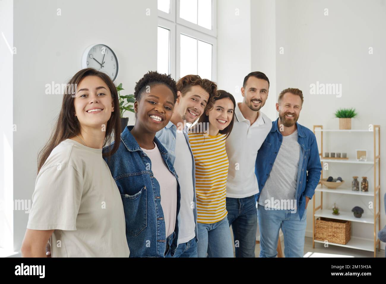 Groupe de jeunes heureux multiethniques hommes et femmes debout ensemble, embrassant et souriant Banque D'Images