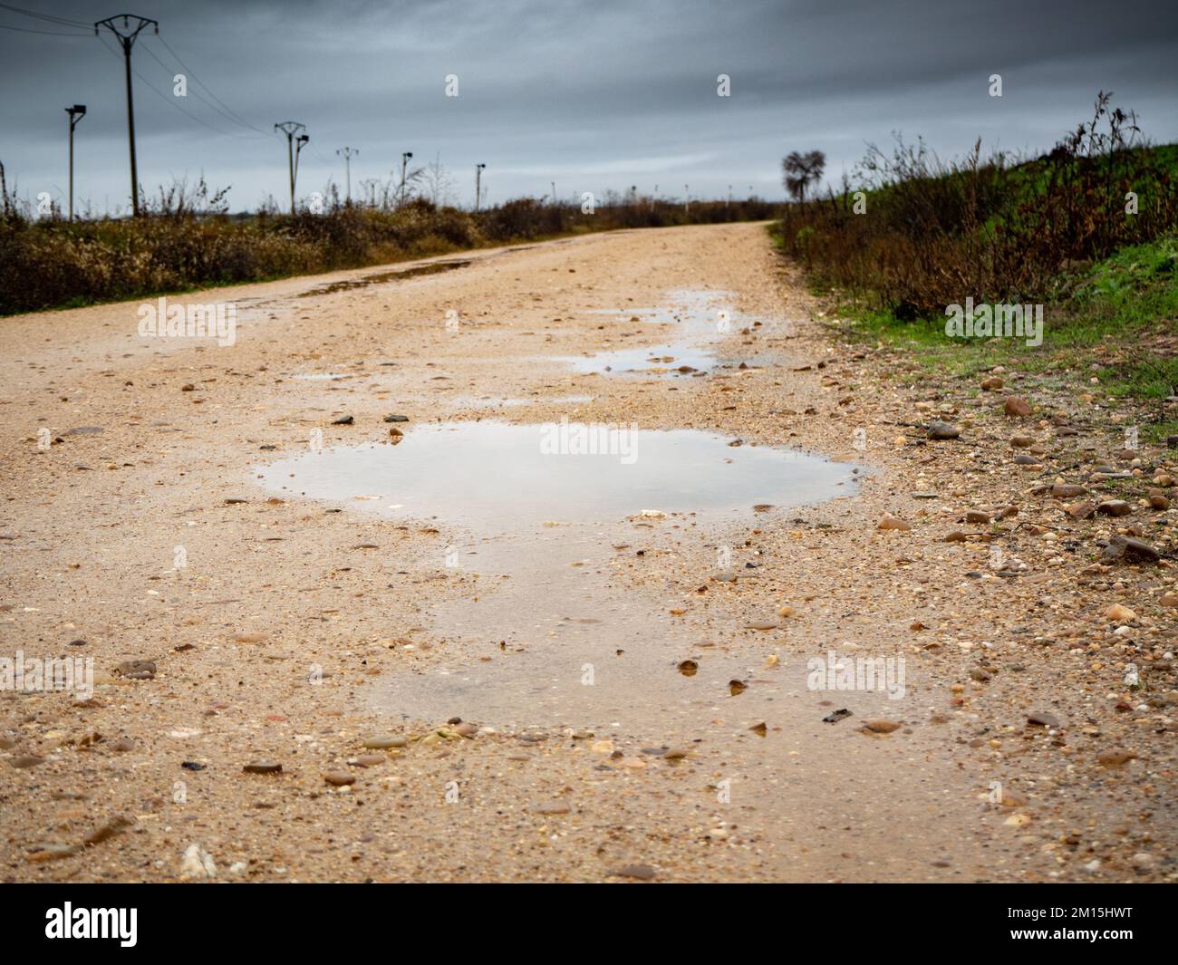 route boueuse sur une route rurale inondée par les pluies hivernales Banque D'Images