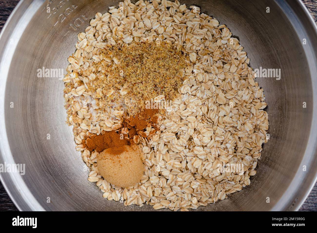 Ingrédients secs pour les flocons d'avoine cuits dans un saladier gros plan : flocons d'avoine, graines de lin moulues, cannelle, cassonade et sel dans un grand bol Banque D'Images
