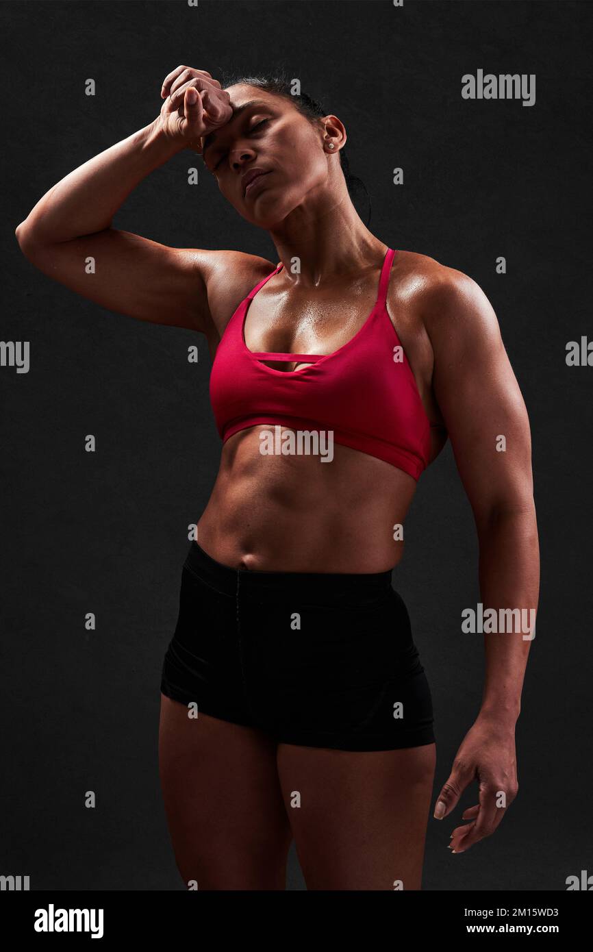 Femme latine forte en haut et short rouge avec corps parfait debout sur fond noir apres l entrainement de fitness Photo Stock Alamy