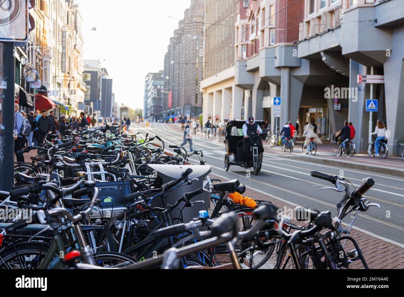 Rue ordinaire d'Amsterdam avec vélos garés et cyclistes, pays-Bas. Banque D'Images