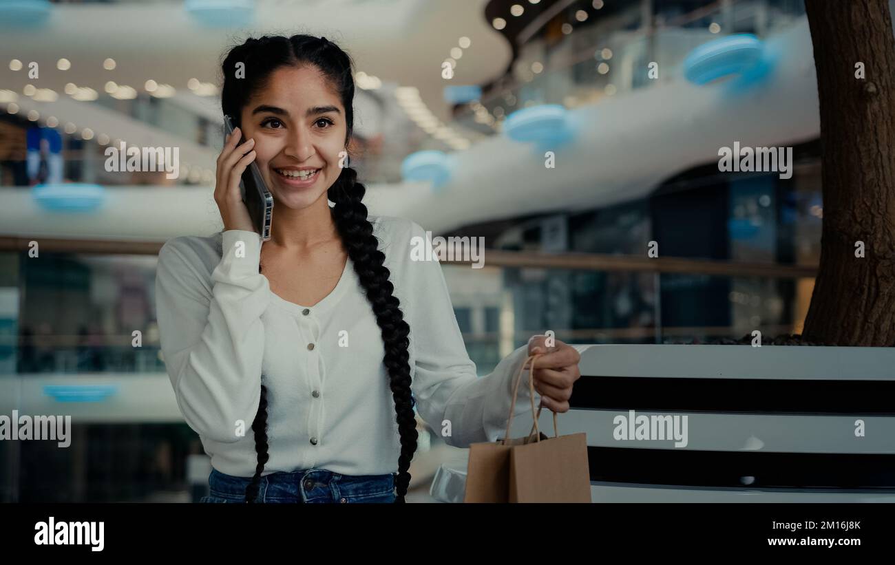 Arabian girl femelle client acheteur femme shopper parler téléphone au centre commercial vérifier achats sacs-cadeaux de luxe magasin de tissu parler Banque D'Images