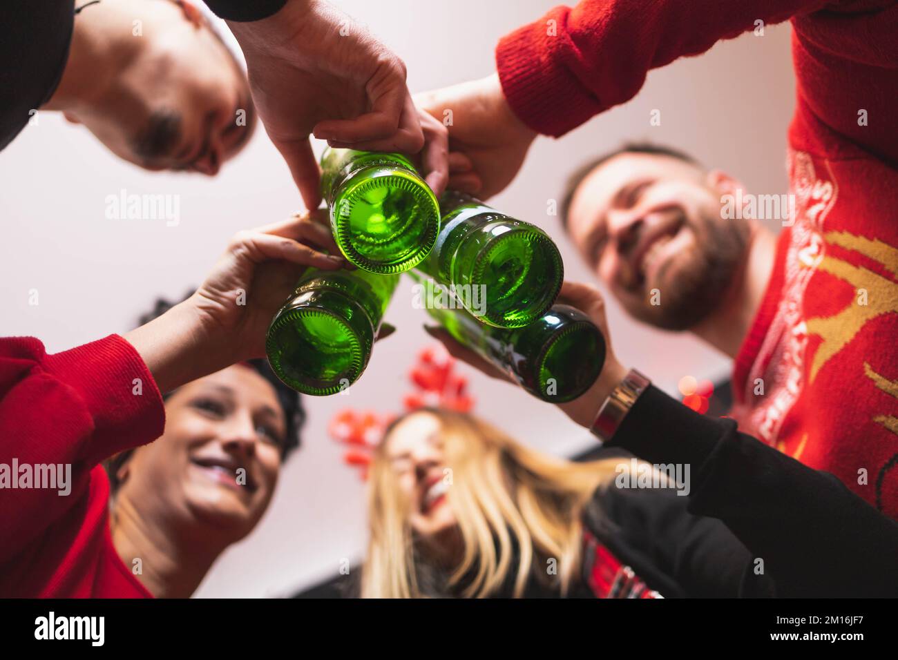 Quatre amis fêtent le nouvel an avec des bouteilles de bière. Concentrez-vous sur les flacons Banque D'Images