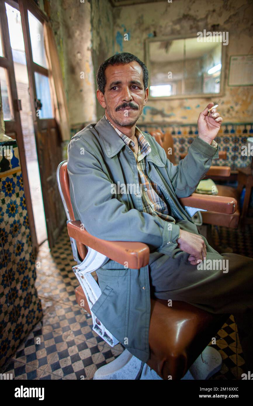 Salon de coiffure fumant de la cigarette en attendant le client au salon de coiffure à Essaouira, Maroc. Banque D'Images