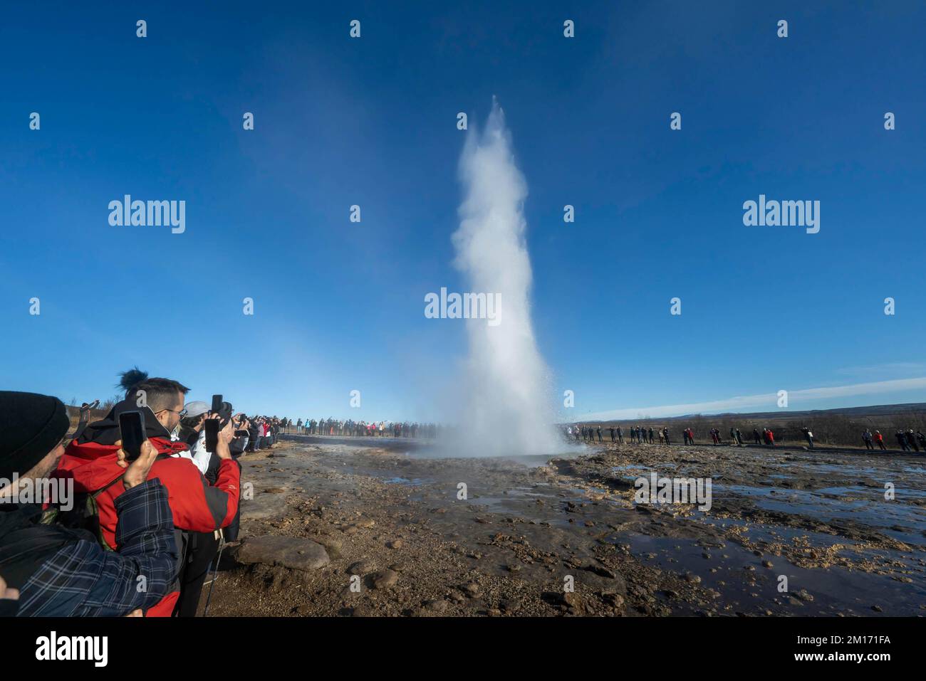 Reikiavik, Islande. 21st octobre 2022. On voit les gens regarder le geyser de Strokkur pendant son éruption au parc géothermique de Haukadalur. La région géothermique près de la rivière Hvità et de la ville de Reykjavík abrite le parc géothermique de Haukadalur. Ici se trouve Strokkur, l'un des geysers les plus célèbres d'Islande, qui éclate en moyenne toutes les 4 à 8 minutes, avec une hauteur moyenne de 15 à 20 mètres, atteignant parfois 40 mètres. Dans le parc, il y a plusieurs caractéristiques géothermiques telles que des piscines de boue, des fumeroles, des dépôts d'algues et d'autres geysers à côté et autour de lui. (Image de crédit : © Jorge cas Banque D'Images