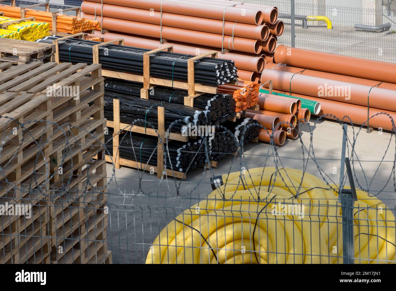 Le tube de plombier du magasin est fendu et les câbles de protection sont  utilisés sous terre. Installations de développement des communications,  grand stock de tubes en PVC et y Photo Stock -