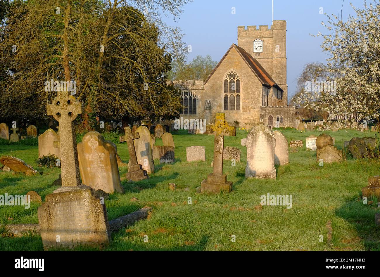 Headcorn : église Saint-Pierre et St-Paul avec cimetière et arbres en fleurs qui illuminent l'or peu après le lever du soleil à Headcorn, Kent, Angleterre Banque D'Images