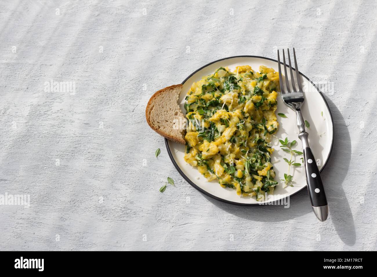 Scrumble œufs avec kale et fromage sur fond gris clair, vue du dessus. délicieux petit déjeuner maison Banque D'Images