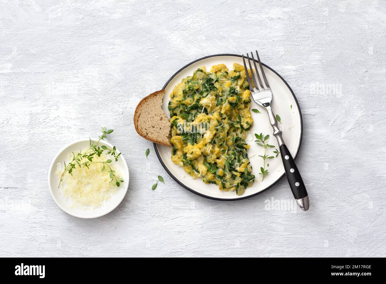 Scrumble œufs avec kale et fromage sur fond gris clair, vue du dessus. délicieux petit déjeuner maison Banque D'Images