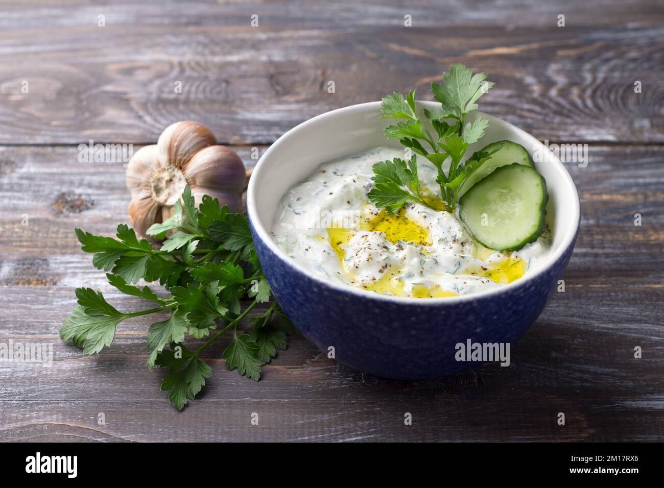 Sauce tzatziki traditionnelle au yaourt grec avec concombres et herbes sur fond de bois Banque D'Images