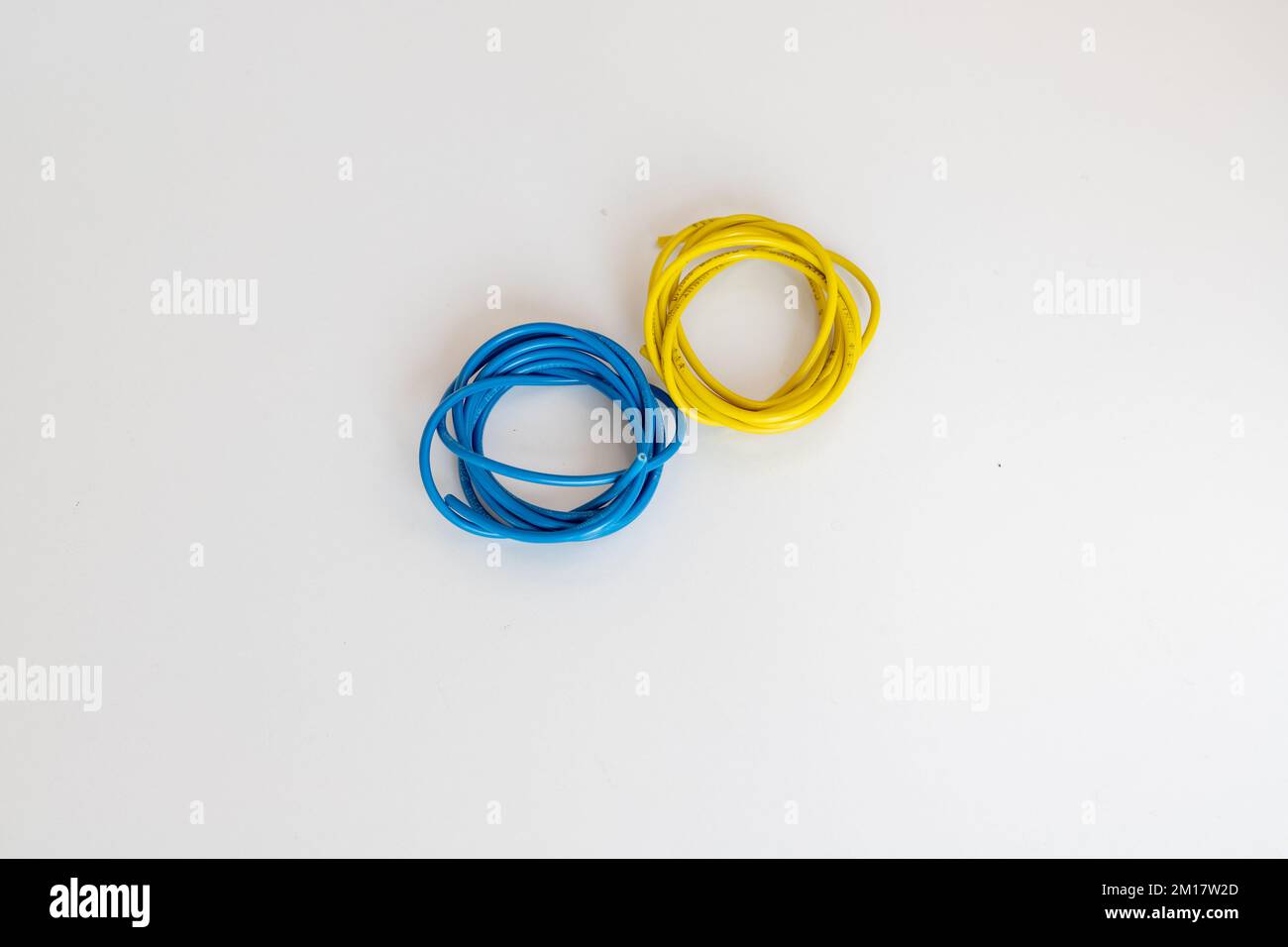 Câbles de couleur jaune et bleu sur fond blanc isolé Banque D'Images