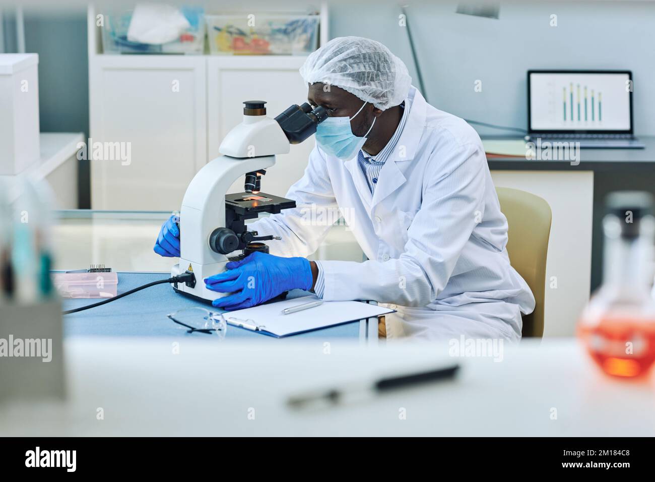Vue latérale d'un scientifique noir utilisant un microscope dans un laboratoire médical, espace de copie Banque D'Images