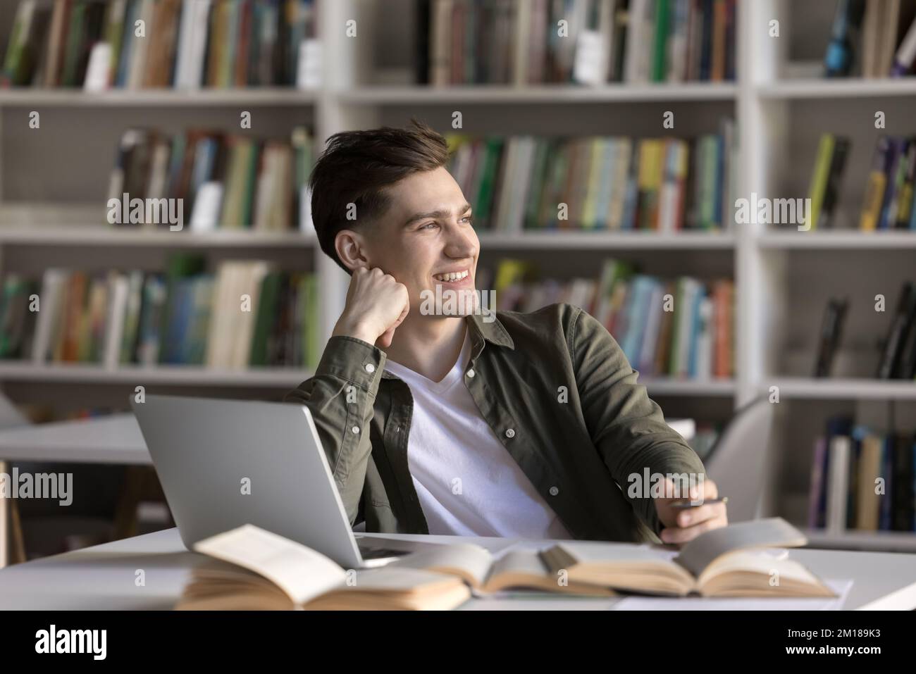 Joyeux étudiant gars de rêve travaillant sur l'article scientifique Banque D'Images