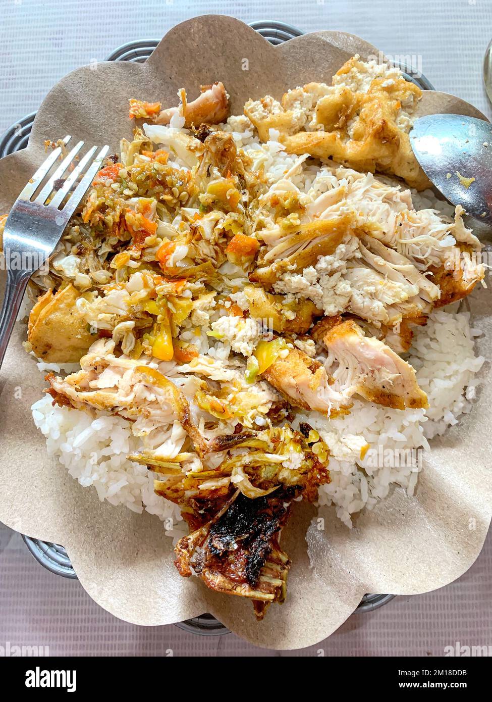 Poulet épicé indonésien avec riz (Nasi Ayam Geprek) mélangé, plat unique originaire de Yogyakarta, Indonésie. Banque D'Images
