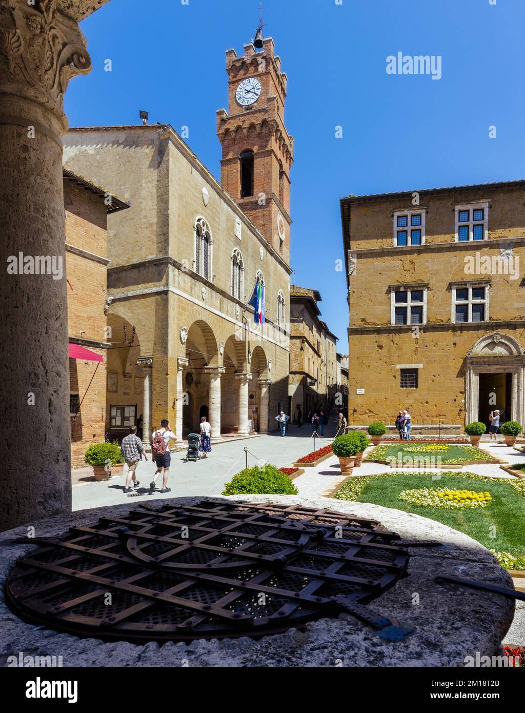 Pienza, province de Sienne, Toscane, Italie. Le Palazzo Comunale sur la Piazza Pio II La grille de fer au premier plan est la couverture d'un puits Renaissance. P Banque D'Images