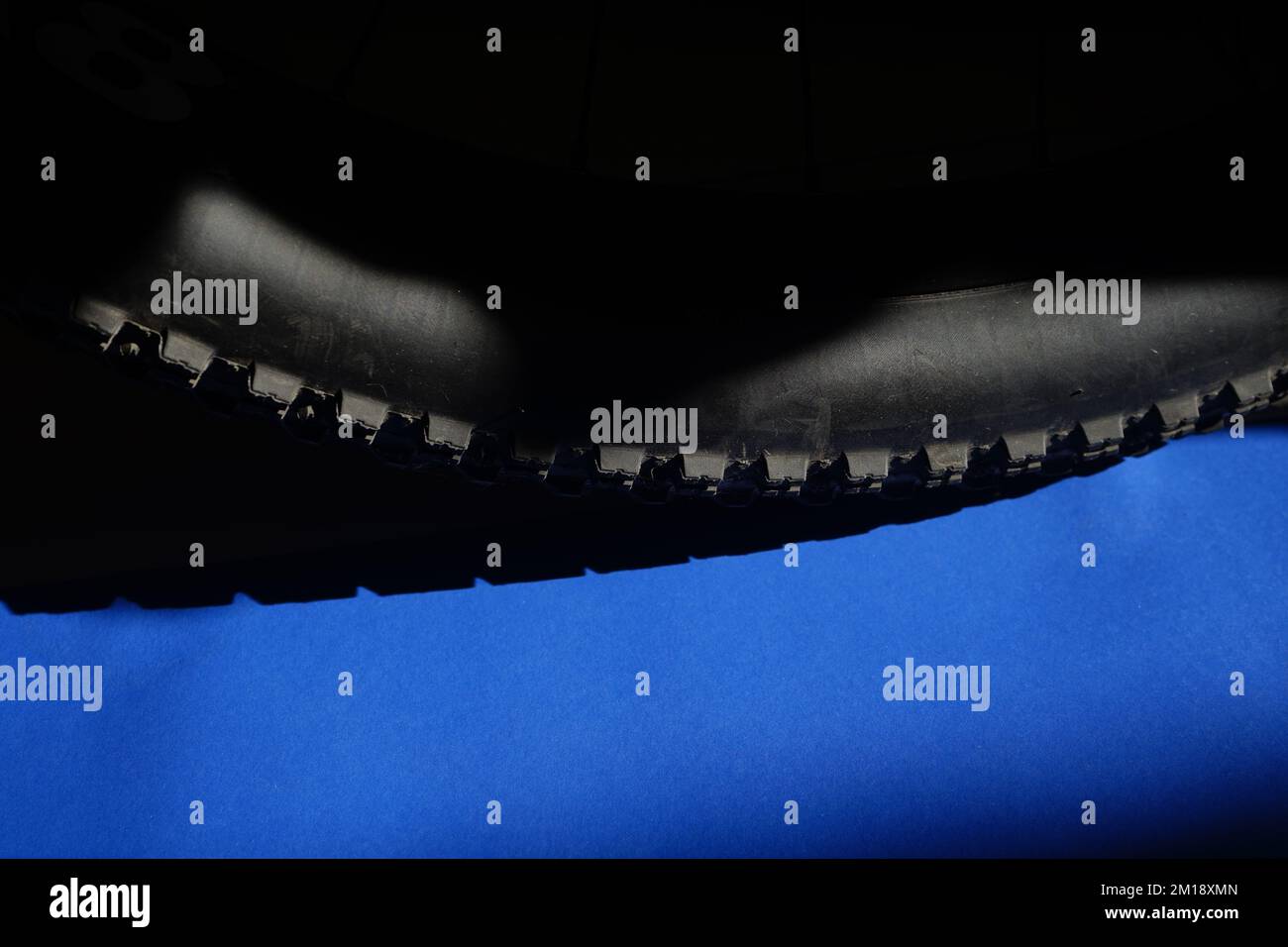 Pneu de vélo tout terrain sur fond bleu noir avec espace de copie Banque D'Images