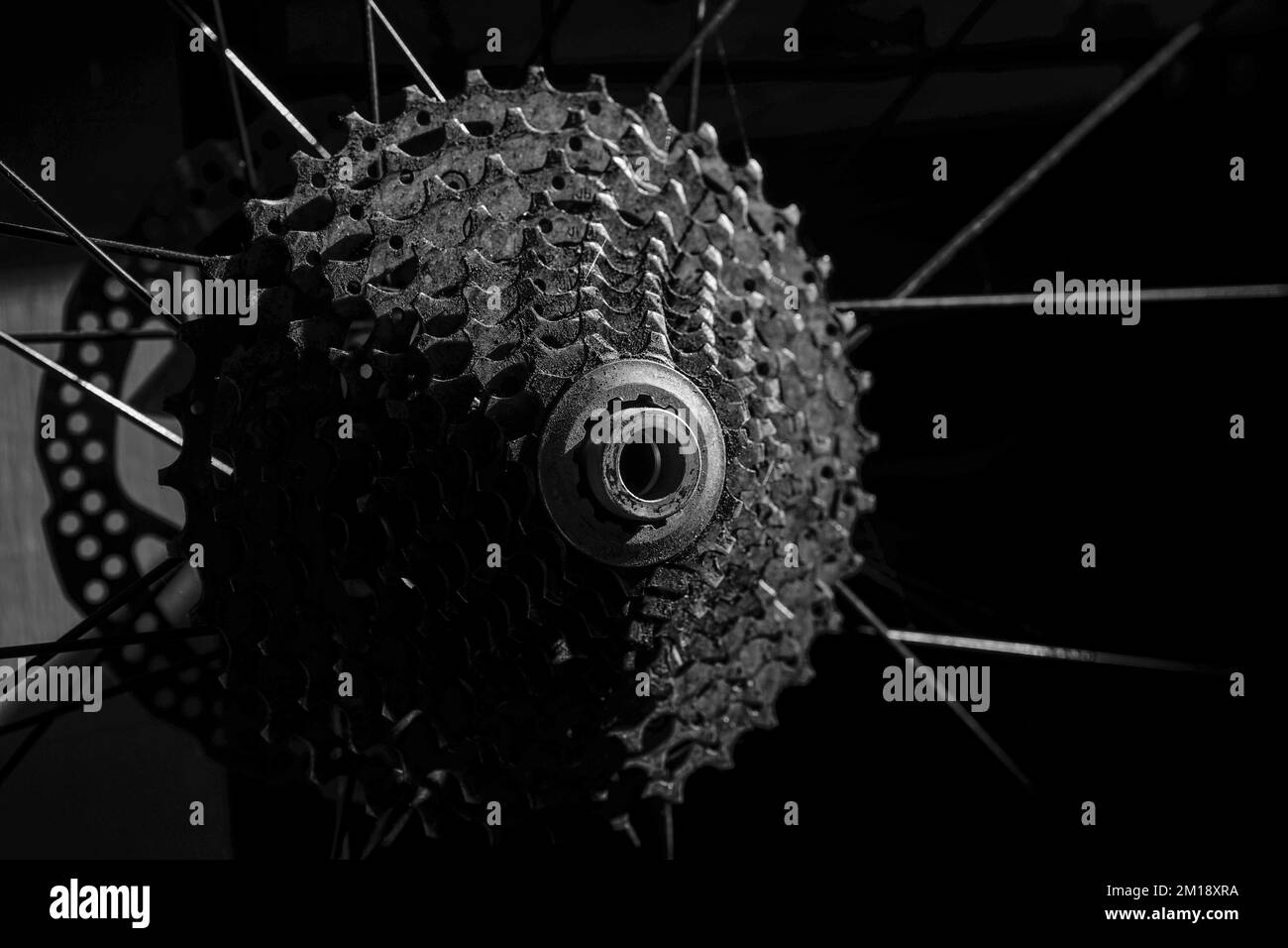 Photo basse lumière de la cassette de vélo tout terrain arrière sur la roue sur fond noir flou Banque D'Images