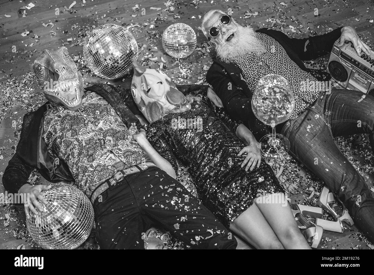 Des gens fous célébrant la fête du carnaval à l'intérieur de la boîte de nuit - Focus sur le masque de poulet - montage noir et blanc Banque D'Images