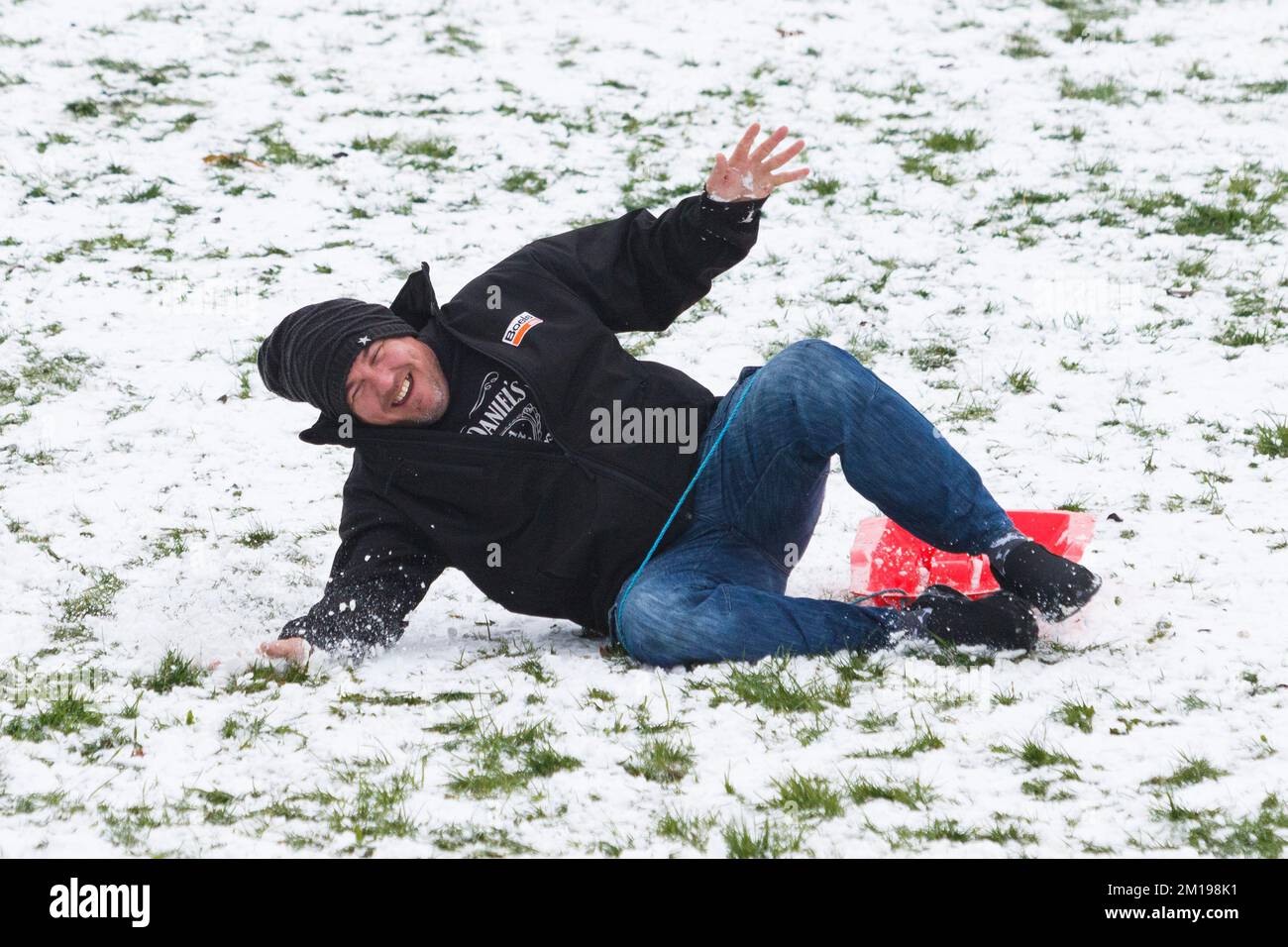 Chippenham, Wiltshire, Royaume-Uni, 11th décembre 2022. Alors que les habitants de Chippenham se réveillent devant leur première neige de l'année, un homme est photographié dans un parc local de Chippenham alors qu'il tombe d'un traîneau lorsqu'il descend une colline. Credit: Lynchpics/Alamy Live News Banque D'Images
