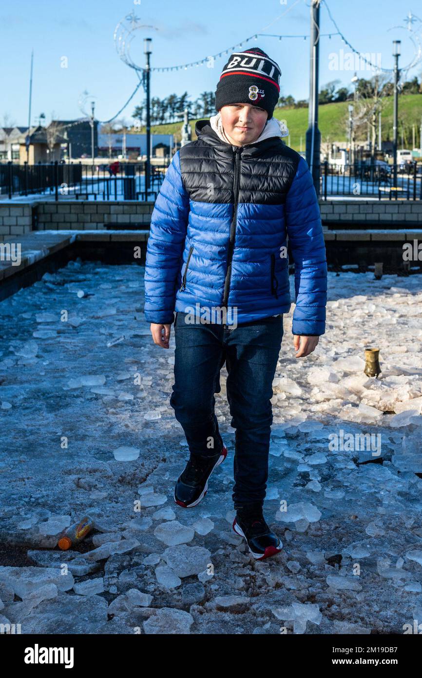 Bantry, West Cork, Irlande. 11th décembre 2022. Des températures inférieures à zéro persistent en Irlande aujourd'hui. Avoir une glissoire sur la fontaine gelée de Bantry était Ryan Coleman, 11 ans, de Skibbereen. Crédit : AG News/Alay Live News Banque D'Images