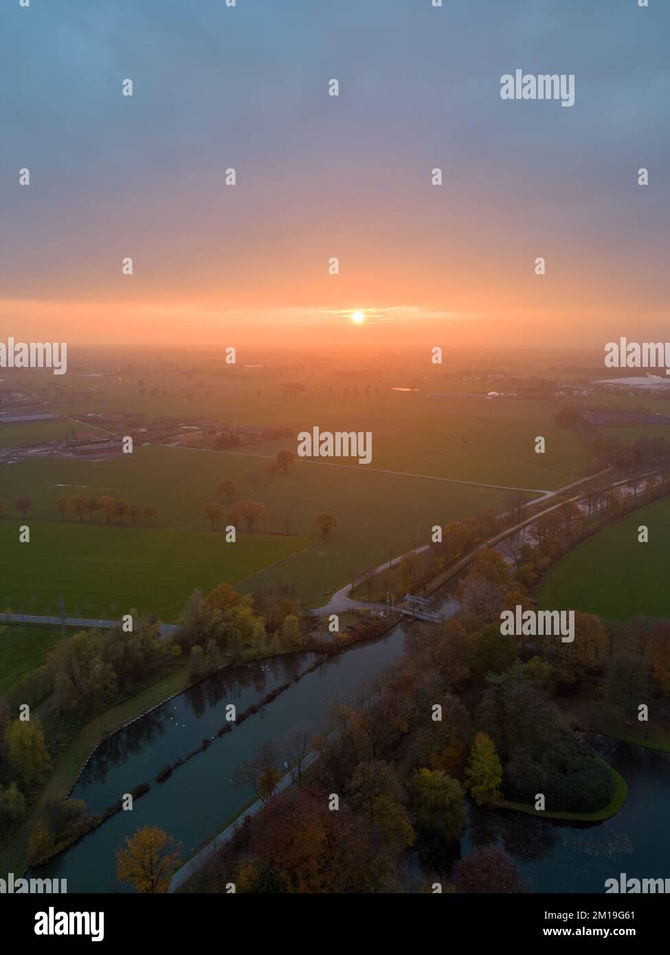 Vue aérienne sur les pâturages luxuriants et les terres agricoles de Belgique sous un ciel spectaculaire et coloré au coucher du soleil. Belle campagne d'anvers avec champs de vert émeraude et prairies. Paysage rural au coucher du soleil. Photo de haute qualité Banque D'Images