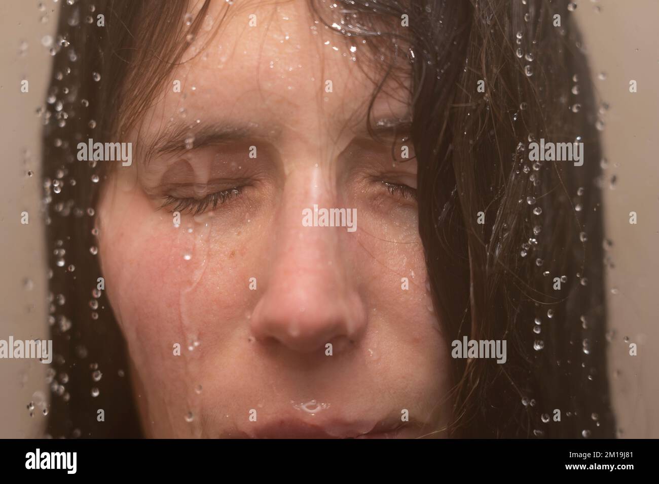 Jeune femme sous la douche avec de l'eau qui coule le long de son