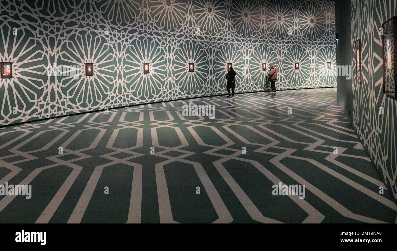 Londres, Royaume-Uni. 11th décembre 2022. Les visiteurs regardent les œuvres exposées. L'espace Curve du Barbican a été transformé en une galerie immersive avec des sols peints à la main et des plafonds aux motifs islamiques pour l'exposition Soheila Sokhanvari Rebel Rebel. L'artiste iranien dépeint des figures culturelles de l'Iran dans des portraits miniatures colorés, montrant la contradiction entre la vie des femmes iraniennes entre la révolution de 1920s et la révolution de 1979. L'exposition est gratuite jusqu'au 26 février 2023. Credit: Imagetraceur/Alamy Live News Banque D'Images