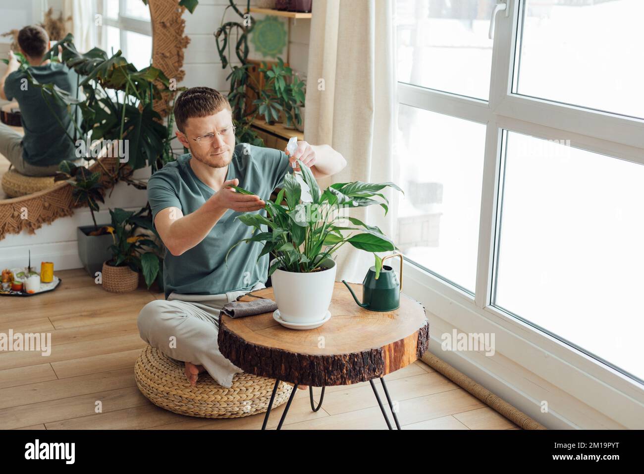 Homme d'âge moyen prenant soin des plantes à la maison. Concept de jardinage à la maison. Banque D'Images