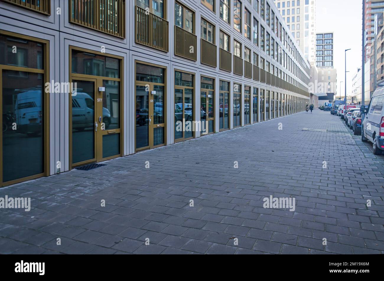 Rotterdam, pays-Bas, 23 novembre 2022: Nouveau bloc résidentiel à Houtlaan faisant face à une vaste et pierreuse plaine de tuiles de pavés en béton standard Banque D'Images