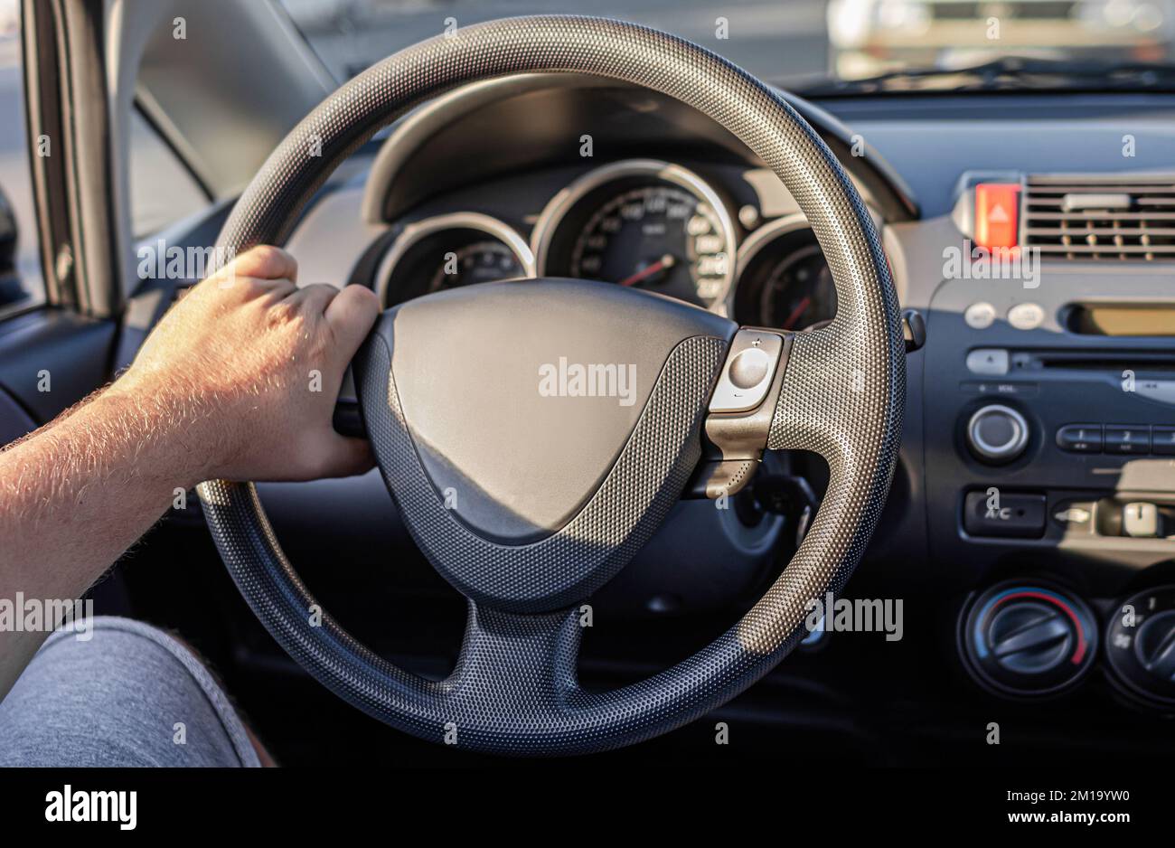 Le conducteur garde les mains sur le volant de la voiture. Banque D'Images