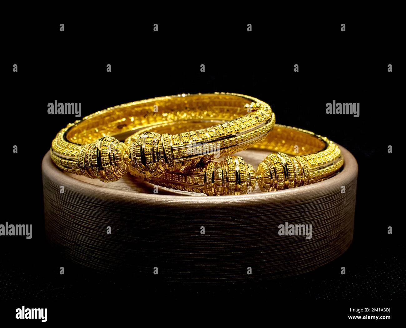 Gros plan de bracelets dorés sur fond noir Banque D'Images