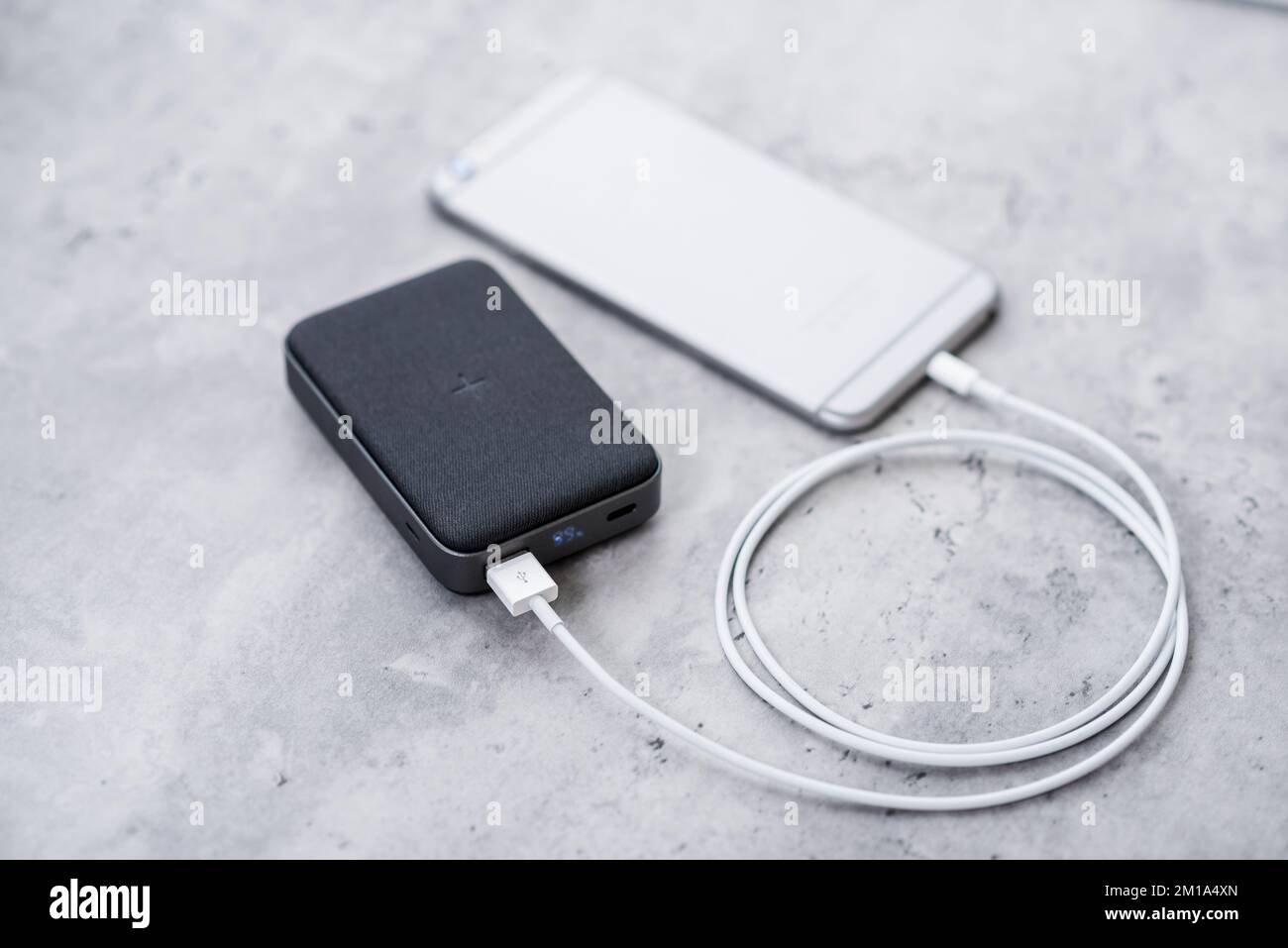 Charge de la batterie du smartphone avec la batterie portable. gros plan  sur la banque d'alimentation grise Photo Stock - Alamy