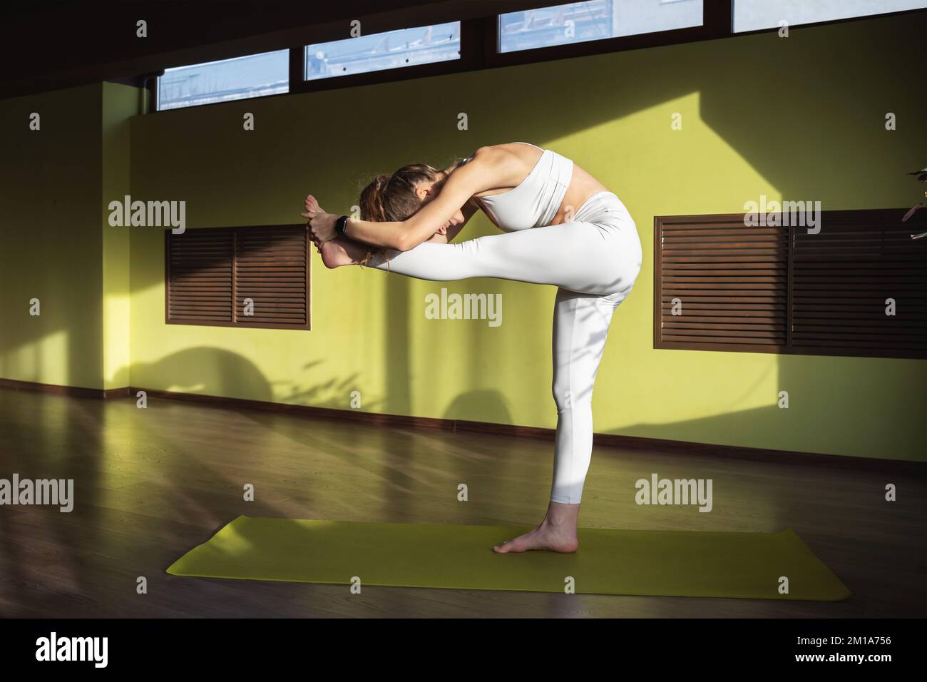 Une jeune femme menant un mode de vie sain et pratiquant le yoga, exécute l'exercice de Uthita Hasta Padangushthasana, la posture de l'étirement de la sidew Banque D'Images