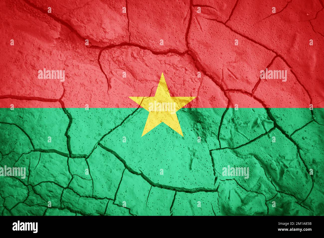 Drapeau du Burkina Faso. Symbole Burkina Faso. Drapeau sur fond de terre sèche fissurée. Burkina Faso drapeau avec concept de sécheresse Banque D'Images