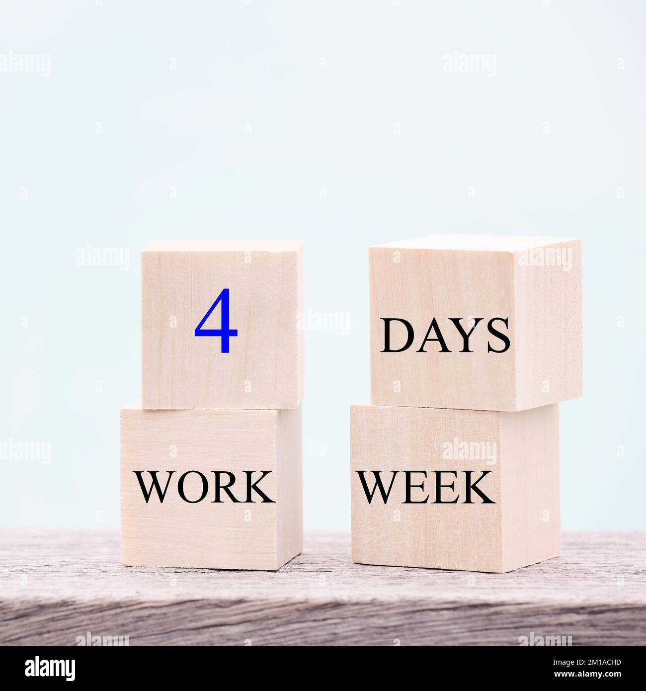 4 jours de travail semaine mots sur cube en bois sur fond bleu. concept de réduction de l'épuisement et des niveaux de stress. copier le carré d'espace Banque D'Images