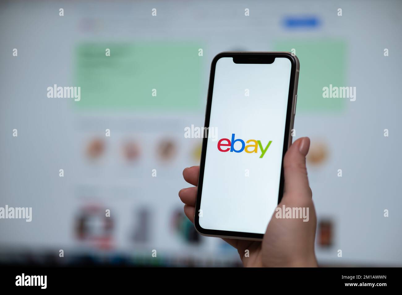 3 décembre 2022, Almaty, Kazakhstan: Une femme tient un smartphone avec une application eBay sur l'arrière-plan d'un ordinateur. Banque D'Images 3 décembre 2022, Almaty, Kazakhstan: Une femme tient un smartphone avec une application eBay sur l'arrière-plan d'un ordinateur. Banque D'Images